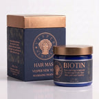 Vesper New York Biotin Hair Masque treatment shown with its navy blue box and matching jar featuring metallic rose gold accents and a gold lid, on a clean white background.